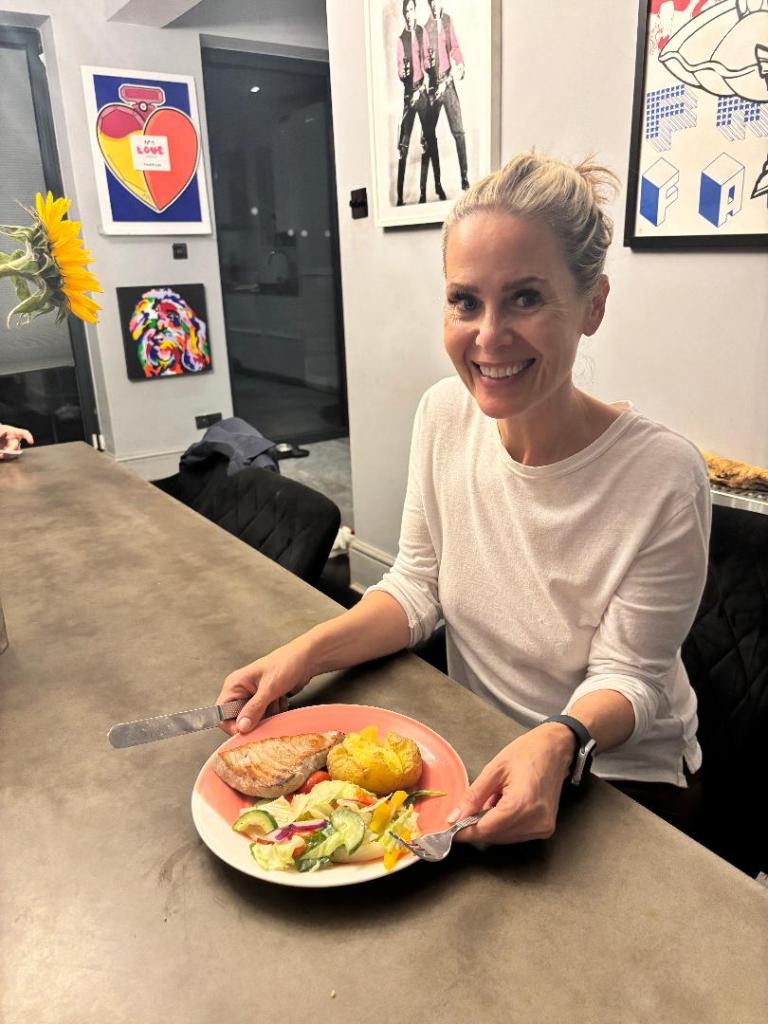 Author pictured with dinner of tuna steak, baked potato and salad